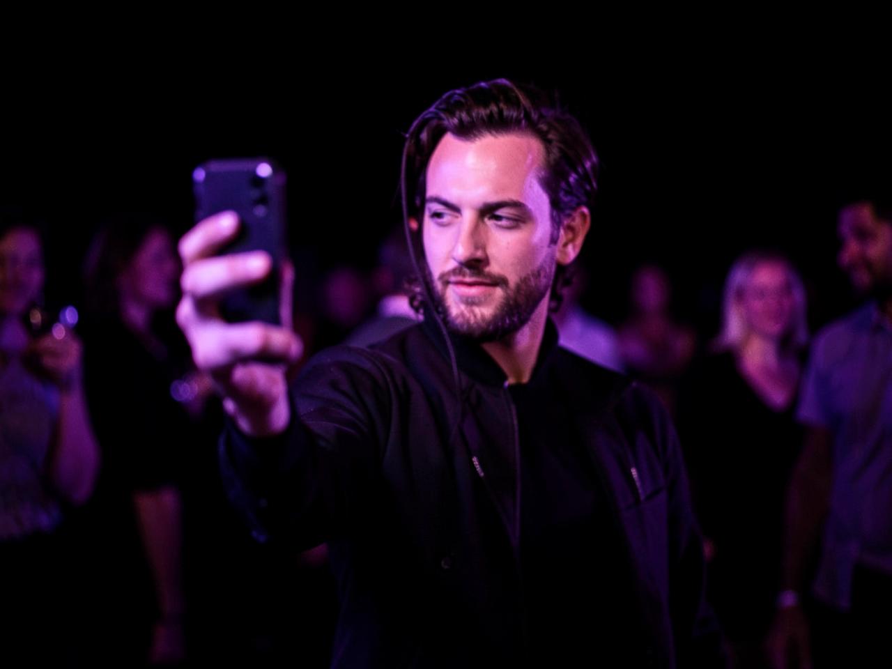 A guest taking a quick selfie at an evening event